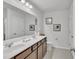 Bathroom featuring double sinks, framed art, and a large mirror at 5372 Fountain Head Ln, Auburn, GA 30011