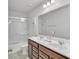 Bathroom featuring double sinks, a large mirror, and a shower-tub combo at 5372 Fountain Head Ln, Auburn, GA 30011