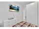 Simple bedroom design with a plaid bedspread, dresser, and mounted flatscreen TV at 5372 Fountain Head Ln, Auburn, GA 30011
