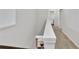 Bright hallway featuring neutral walls and carpet, with a bathroom visible in the background at 5372 Fountain Head Ln, Auburn, GA 30011
