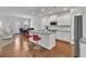 Modern kitchen with white cabinets, stainless steel appliances, a large island, and hardwood floors at 5372 Fountain Head Ln, Auburn, GA 30011
