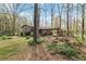 Spacious backyard with mature trees, swings, and a home with a covered patio, offering ample outdoor space at 587 Coast Oak Cir, Lawrenceville, GA 30046