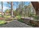 Backyard view with a stone path leading to a deck, showcasing lush greenery and mature trees at 587 Coast Oak Cir, Lawrenceville, GA 30046