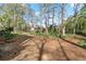 Expansive backyard featuring mature trees and a mix of natural terrain, offering a serene outdoor space at 587 Coast Oak Cir, Lawrenceville, GA 30046