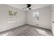 This bedroom features neutral walls and gray carpeting, along with a ceiling fan and two windows at 587 Coast Oak Cir, Lawrenceville, GA 30046