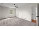 Light-filled bedroom with plush carpeting, ceiling fan, and a door to the en suite bathroom at 587 Coast Oak Cir, Lawrenceville, GA 30046