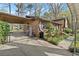 Exterior of home featuring a covered carport and beautifully landscaped yard with mature trees at 587 Coast Oak Cir, Lawrenceville, GA 30046