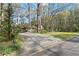 View of home with well-maintained lawn and convenient carport, set amidst tall trees at 587 Coast Oak Cir, Lawrenceville, GA 30046