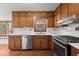 Well-lit kitchen featuring stainless steel appliances, wood cabinets, white countertops, and backsplash at 587 Coast Oak Cir, Lawrenceville, GA 30046
