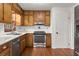 The well-equipped kitchen features stainless steel appliances, wood cabinets, and a white tiled backsplash at 587 Coast Oak Cir, Lawrenceville, GA 30046