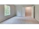 Spacious carpeted bedroom featuring a walk-in closet and a large window at 1097 Bodega Loop, Locust Grove, GA 30248