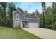 Two-story home featuring gray siding, white trim, an attached two-car garage, and a concrete driveway at 1097 Bodega Loop, Locust Grove, GA 30248