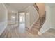 Spacious foyer featuring a staircase, beautiful wood-look flooring, and an entry door at 1097 Bodega Loop, Locust Grove, GA 30248