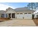 Single-story house with an attached two-car garage and a charming front porch, showcasing comfortable living at 126 Cottage Club Dr, Locust Grove, GA 30248