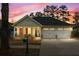 Charming single story home boasts a well-manicured lawn and attached two car garage during sunset at 126 Cottage Club Dr, Locust Grove, GA 30248