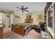 Comfortable main bedroom featuring a queen-sized bed, ceiling fan, sitting area, and wooden accents at 126 Cottage Club Dr, Locust Grove, GA 30248