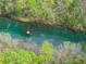 Breathtaking aerial view of a crystal-clear river flowing through a lush, rocky landscape at 1870 Chattahoochee Run Dr, Suwanee, GA 30024