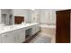 Well-lit bathroom featuring dual sinks, a soaking tub, and a decorative rug at 1870 Chattahoochee Run Dr, Suwanee, GA 30024