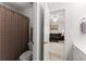 Bathroom with a tub and shower, toilet, and view through the open door to the living space at 1870 Chattahoochee Run Dr, Suwanee, GA 30024