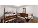 Bedroom with four poster bed, patterned rug, and accent furniture at 1870 Chattahoochee Run Dr, Suwanee, GA 30024
