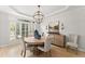 Formal dining room with elegant light fixture, decorative furniture and natural light at 1870 Chattahoochee Run Dr, Suwanee, GA 30024