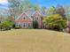 Charming two-story brick home with a well-manicured lawn and mature trees offering great curb appeal at 1870 Chattahoochee Run Dr, Suwanee, GA 30024