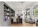 Bright and airy home office with built in shelving, hardwood floors, and a comfortable seating area at 1870 Chattahoochee Run Dr, Suwanee, GA 30024