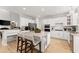 Spacious white kitchen featuring stainless appliances, island with seating, and eat-in breakfast area at 1870 Chattahoochee Run Dr, Suwanee, GA 30024