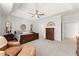 Spacious main bedroom featuring tray ceiling with ceiling fan and sitting area at 1870 Chattahoochee Run Dr, Suwanee, GA 30024