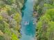 Overhead shot of a river winding through verdant forest, clear water visible from above at 1870 Chattahoochee Run Dr, Suwanee, GA 30024