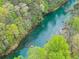 Scenic aerial view of a tranquil river surrounded by lush greenery in a wooded area at 1870 Chattahoochee Run Dr, Suwanee, GA 30024