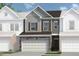 Charming townhome featuring a two-car garage with stone accents and a mix of gray and brown siding at 147 Ravencliff Dr # 147, Austell, GA 30168