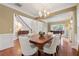 An elegant dining room with hardwood floors, crown molding, and ample space for entertaining guests around the large table at 310 Kingspring Ct, Roswell, GA 30076
