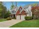 Charming home exterior with brick accents, two-car garage, and well-manicured landscaping at 310 Kingspring Ct, Roswell, GA 30076
