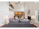 A bright living room featuring high ceilings, hardwood floors, a fireplace, and an open layout leading to the kitchen at 310 Kingspring Ct, Roswell, GA 30076