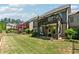 View of the back of the home, upper deck, lower covered patio, fenced in backyard and lawn at 95 Nesbit Reserve Ct, Alpharetta, GA 30022