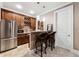 Basement bar with stainless steel refrigerator, granite countertops, and two leather swivel bar stools at 95 Nesbit Reserve Ct, Alpharetta, GA 30022
