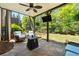 Covered patio with stone flooring, an outdoor ceiling fan, and comfortable seating and a TV at 95 Nesbit Reserve Ct, Alpharetta, GA 30022