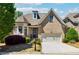 Charming brick home features a two-car garage, beautifully landscaped front yard, and dormer window at 95 Nesbit Reserve Ct, Alpharetta, GA 30022