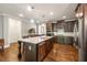 Modern kitchen with a large center island, stainless steel appliances, granite countertops, and dark wood cabinets at 95 Nesbit Reserve Ct, Alpharetta, GA 30022