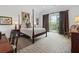 Spacious primary bedroom with a four-poster bed, private balcony, and neutral carpeting at 3101 Howell Mill Nw Rd # 301, Atlanta, GA 30327