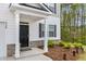 Close-up of a home's entry featuring a black front door, white pillars, and neatly landscaped yard at 3736 Chevington Se Ct, Atlanta, GA 30354