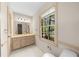 Well-lit bathroom featuring a large window, a vanity with drawers, and neutral tiling at 5145 Davantry Dr, Dunwoody, GA 30338