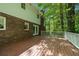 Spacious wood deck with white railings and access to the brick home's interior at 5145 Davantry Dr, Dunwoody, GA 30338