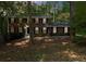 Charming two-story brick home with black shutters and a well-manicured front lawn in a wooded lot at 5145 Davantry Dr, Dunwoody, GA 30338
