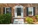 Inviting entryway featuring a black front door with sidelights, white trim, and a brick facade at 5145 Davantry Dr, Dunwoody, GA 30338