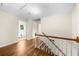 Well-lit hallway with hardwood flooring and white trim, showcasing the staircase and multiple entryways at 5145 Davantry Dr, Dunwoody, GA 30338