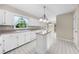 Bright kitchen with white cabinetry, tiled floors, an island, and ample counter space at 5145 Davantry Dr, Dunwoody, GA 30338