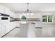Well-lit kitchen with white cabinets, island, and tile flooring at 5145 Davantry Dr, Dunwoody, GA 30338