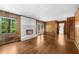 Spacious living room with wood paneled walls, hardwood floors, fireplace, and large windows at 5145 Davantry Dr, Dunwoody, GA 30338